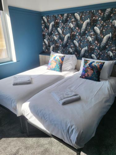 two twin beds in a room with a wall with at 272-274 Accommodation AT in Blackpool