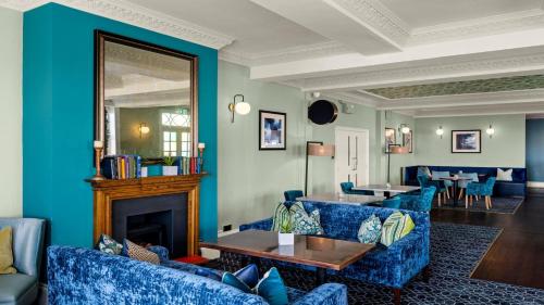 a living room with blue furniture and a fireplace at Kingscliff, BW Signature Collection in Clacton-on-Sea