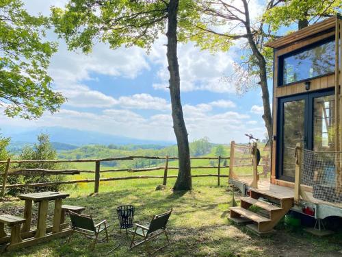a cabin in the woods with a picnic table and chairs at Terrasse des Chambarans - Panorama sur le Vercors in Bessins
