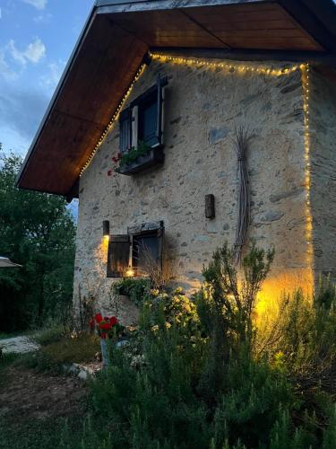 a stone building with a window with lights on it at il Bosco in Roccaforte Mondovì