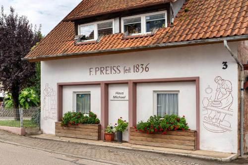 a small white building with two windows and flowers at Ferienwohnung, 50qm, Terrasse in Sexau