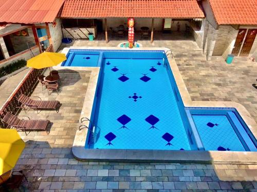 an overhead view of a swimming pool with an umbrella at Pousada Familly Porto de Galinhas in Porto De Galinhas