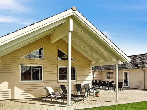 a house with chairs on a patio in front of it at 20 person holiday home in Hasselberg in Kappeln