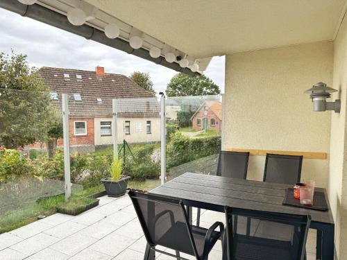 a table and chairs on a patio with a view at Hafenhäuser Breege - Whg 10 Boddenpfoten in Breege