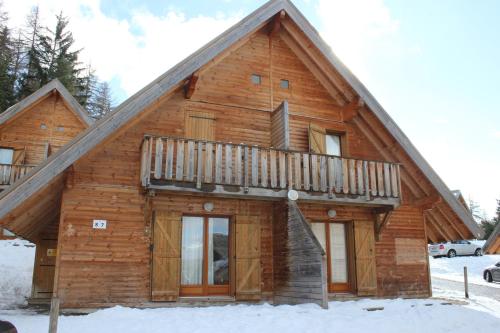 a log cabin in the snow with a balcony at Flocons du Soleil by Actisource in La Joue du Loup