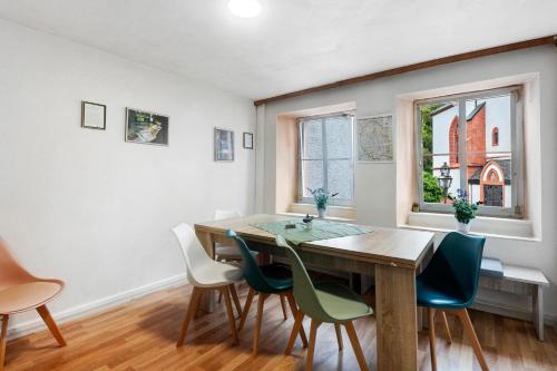 a dining room with a wooden table and chairs at Ferienhaus Zum Burgfried in Neuerburg