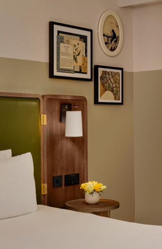 a bedroom with a bed and a table with flowers at Mount Royal Hotel Edinburgh by The Unlimited Collection in Edinburgh