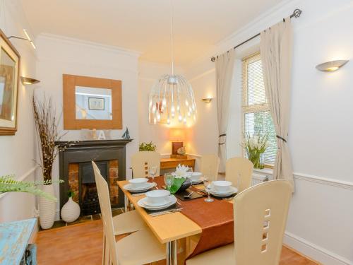 a dining room with a table and chairs and a fireplace at Number 1 Admiralty Cottages in Alverstoke