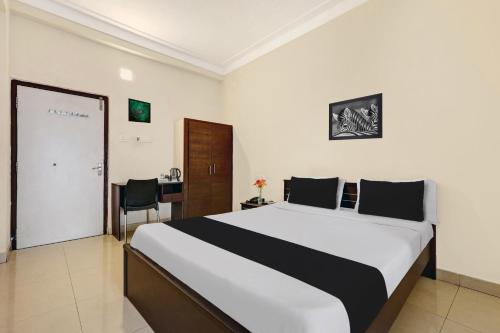 a bedroom with a bed and a desk in it at Super Collection O jagadamba Junction near Beach Road in Visakhapatnam
