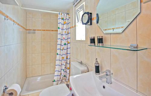 une salle de bain avec un lavabo, des toilettes et une baignoire dans l'établissement Ferienhaus Waren Müritz, à Warenshof