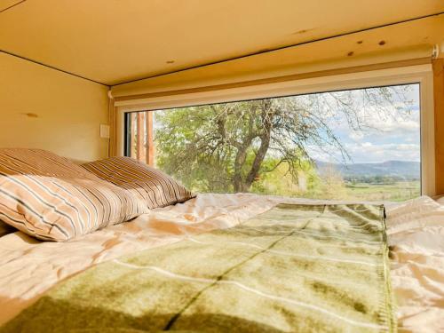 a bedroom with a bed and a large window at La Clairière de Peylenc - Refuge en Velay in Saint-Pierre-Eynac