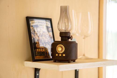 a lamp sitting on a shelf next to a picture at La Clairière de Peylenc - Refuge en Velay in Saint-Pierre-Eynac