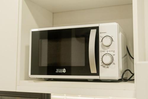a microwave oven sitting on top of a shelf at Departamento de lujo en zona Carmelitas in Asuncion