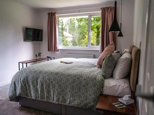 a bedroom with a large bed and a window at Moorlands in Chilcompton