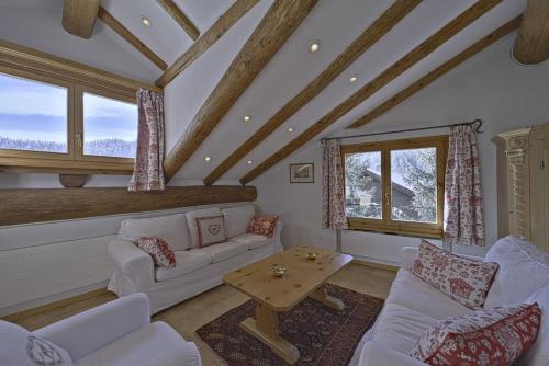 a living room with white couches and a table at Chesa Suvretta - Celerina in Celerina