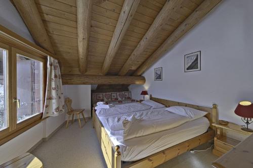 a bedroom with a bed and a wooden ceiling at Chesa Suvretta - Celerina in Celerina