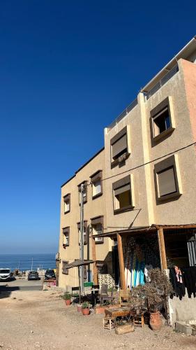 a building on the beach next to the ocean at Imsouane Vibe Surf house in Imsouane