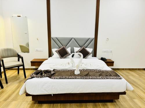 a hotel room with a bed with a white ribbon on it at Nicolas Farm & Resort in Mansar
