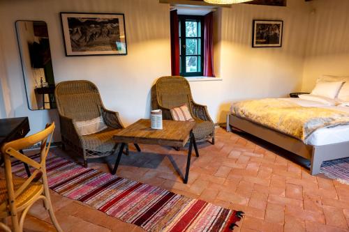 a bedroom with a bed and two chairs and a table at Ugron Castle Fiatfalva in Cristuru Secuiesc