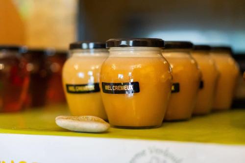 a row of jars of orange juice on a shelf at Lodge Grand Confort en Nature - Salle de bain italienne - 10 min A7 in Mondragon