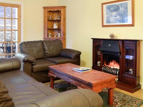 a living room with a couch and a fireplace at The Stables At Old Vicarage Cottage in Abergele
