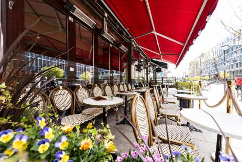 a row of tables and chairs on a patio with flowers at ProfilHotels Central in Stockholm