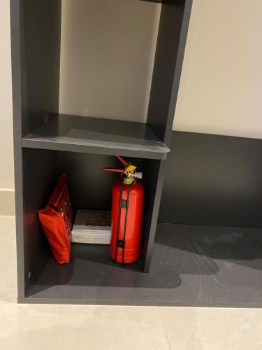 a shelf with a red suitcase and a book at Simple studio in Jeddah