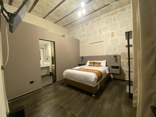 a bedroom with a king sized bed and a bathroom at Inti Paqari in Arequipa