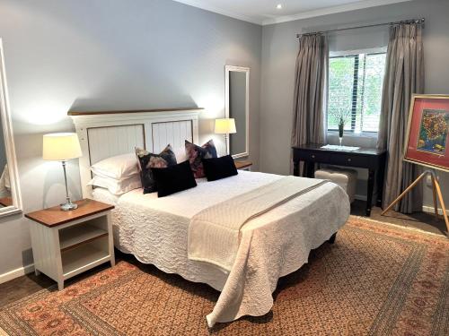 a bedroom with a large bed and a desk at 10onErika Franschhoek in Franschhoek