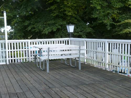 a bench on a deck next to a white fence at Söruper Hof in Sörup