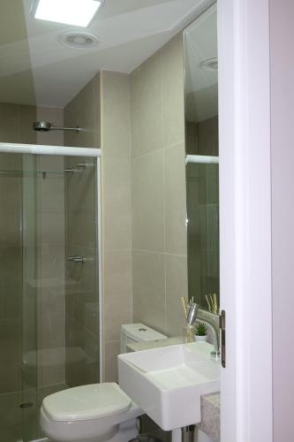 a bathroom with a toilet and a sink and a shower at Quarto e sala irretocável Beach Class Ondina in Salvador
