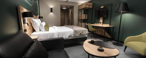 a hotel room with a bed and a couch and a table at Hotel OstOria, BW Signature Collection in Marsac-sur-lʼIsle