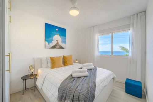 a white bedroom with a bed and a window at Playa La Arena 2 Bed Apartment in Puerto de Santiago