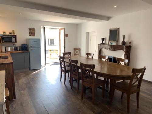 a kitchen and dining room with a wooden table and chairs at Le Grand Terroir - 12 pers - centre de Dormans in Dormans