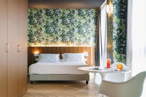 a bedroom with a bed with a large painting on the wall at Collini Rooms, WorldHotels Crafted in Milan