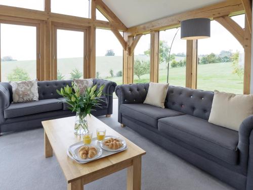 a living room with blue couches and a coffee table at The Row in Much Marcle