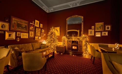 a living room with a christmas tree and a couch and a mirror at Bellinter House Hotel & Spa in Navan