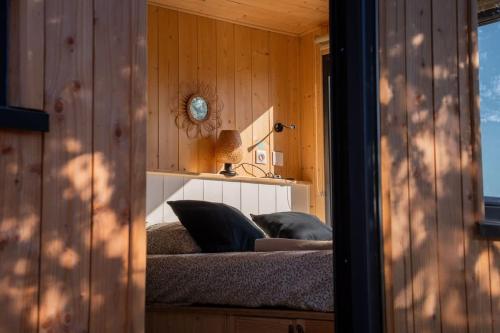 a bedroom with a bed in a room with wooden walls at Lodge en Nature - 30 min Saint-Emilion - Salle de bain à l'italienne in Mouliets-et-Villemartin