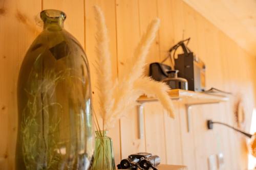 a large glass vase sitting on a table with a plant at Lodge en Nature - 30 min Saint-Emilion - Salle de bain à l'italienne in Mouliets-et-Villemartin