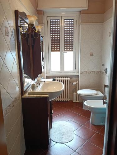 un bagno con lavandino, WC e specchio di Camera Pero con bagno in comune a Pero