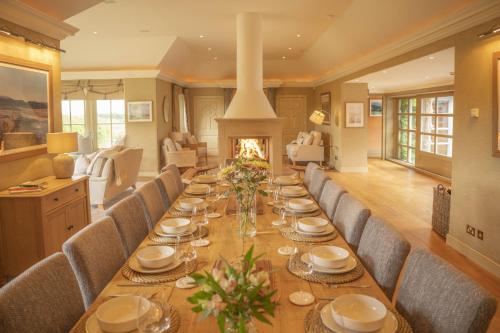 a long dining room table with chairs and a fireplace at Drum Lodge in Nethy Bridge