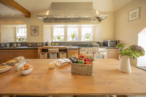 a kitchen with a wooden table with fruit on it at Drum Lodge in Nethy Bridge