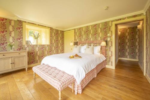 a bedroom with a large bed with floral wallpaper at Drum Lodge in Nethy Bridge