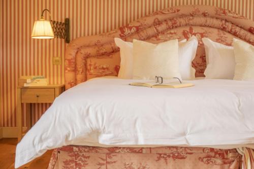 a bedroom with a large white bed with a large headboard at Drum Lodge in Nethy Bridge
