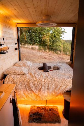 PinayにあるLodge Grand Confort - 1h de Lyon - Vue sur Loireの大きな窓が備わる小さな部屋のベッド1台分です。