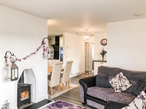a living room with a couch and a fireplace at Ballygroggan Bungalow - Uk38174 in Machrihanish