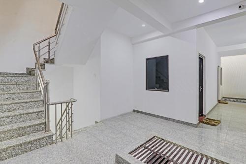 uma escada num quarto com paredes brancas em The Silver Tree em Nalmatha