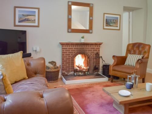 ein Wohnzimmer mit Couch und Kamin in der Unterkunft Wood Cottage in Cheriton
