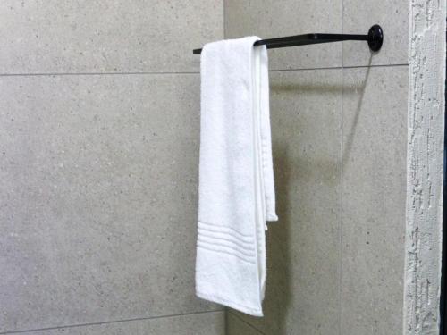 un asciugamano bianco appeso a un portasciugamani in bagno di Wild Olive Luxury Accommodation a Hutton Heights