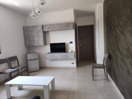 a living room with a table and chairs and a television at La Casetta di Bea in Bernalda